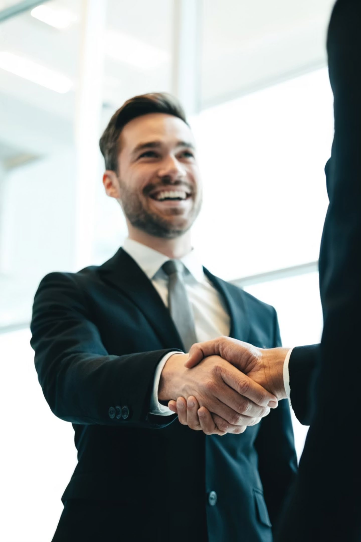 A smiling tax professional shaking hands with a client